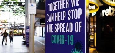 A sign in a public area reads "Together, we can help stop the spread of COVID-19."