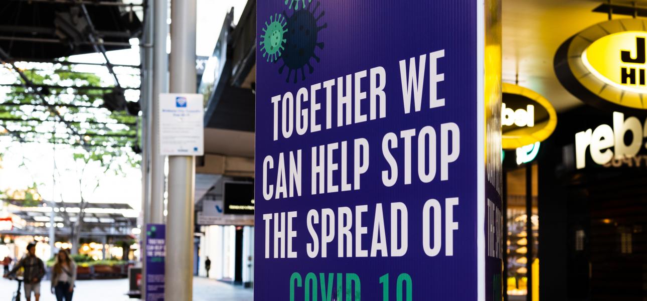 A sign in a public area reads "Together, we can help stop the spread of COVID-19."